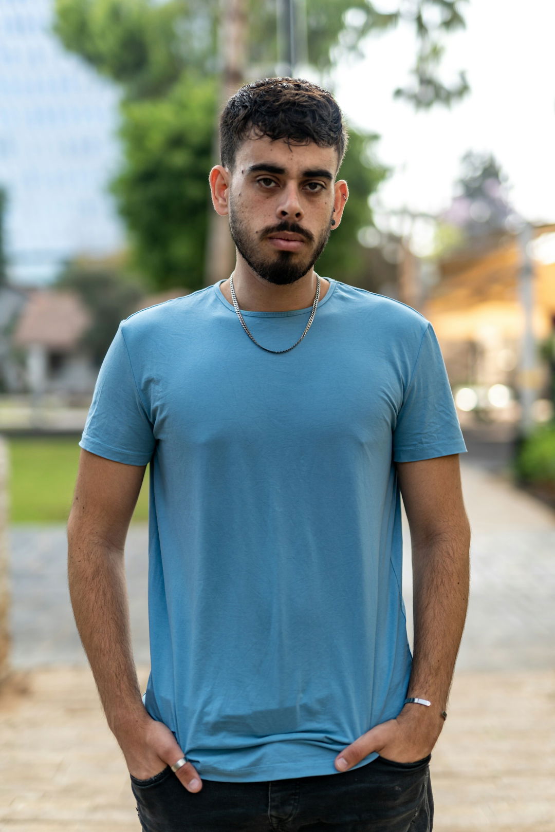 a man in a blue shirt standing on a sidewalk